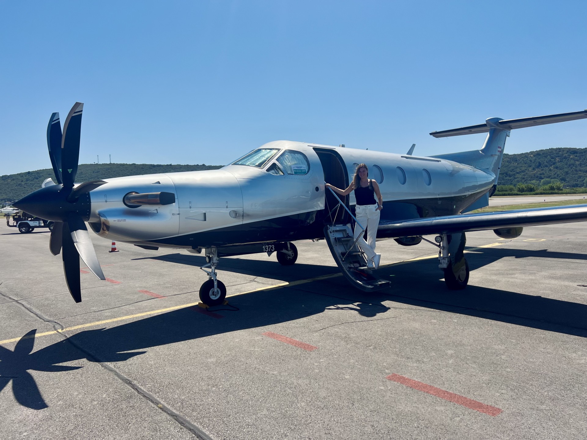 Isabell Buchner, founder of ABATON JetJourneys and private pilot, at the steps of a private aircraft