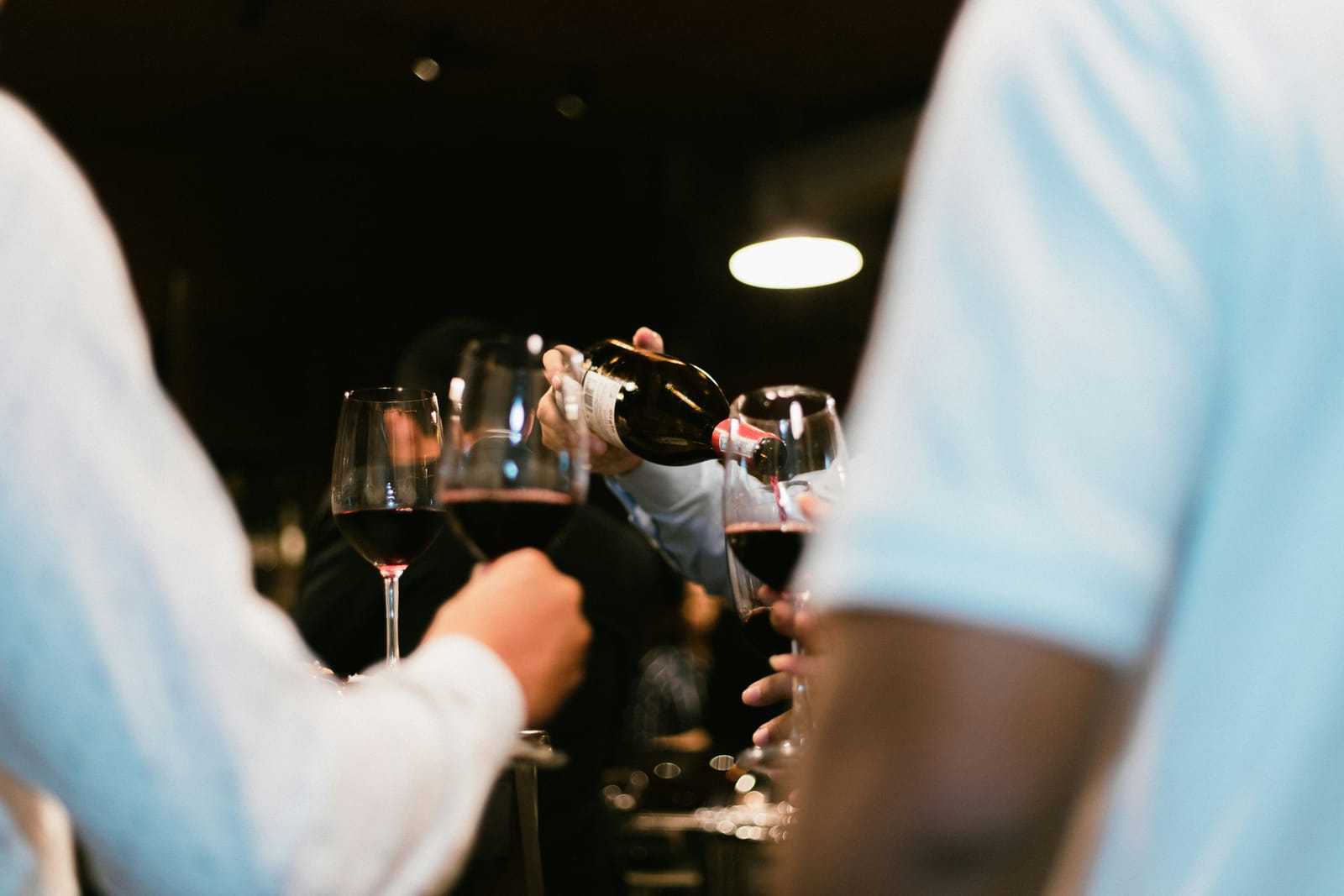 Red wine being poured into glasses at a tasting