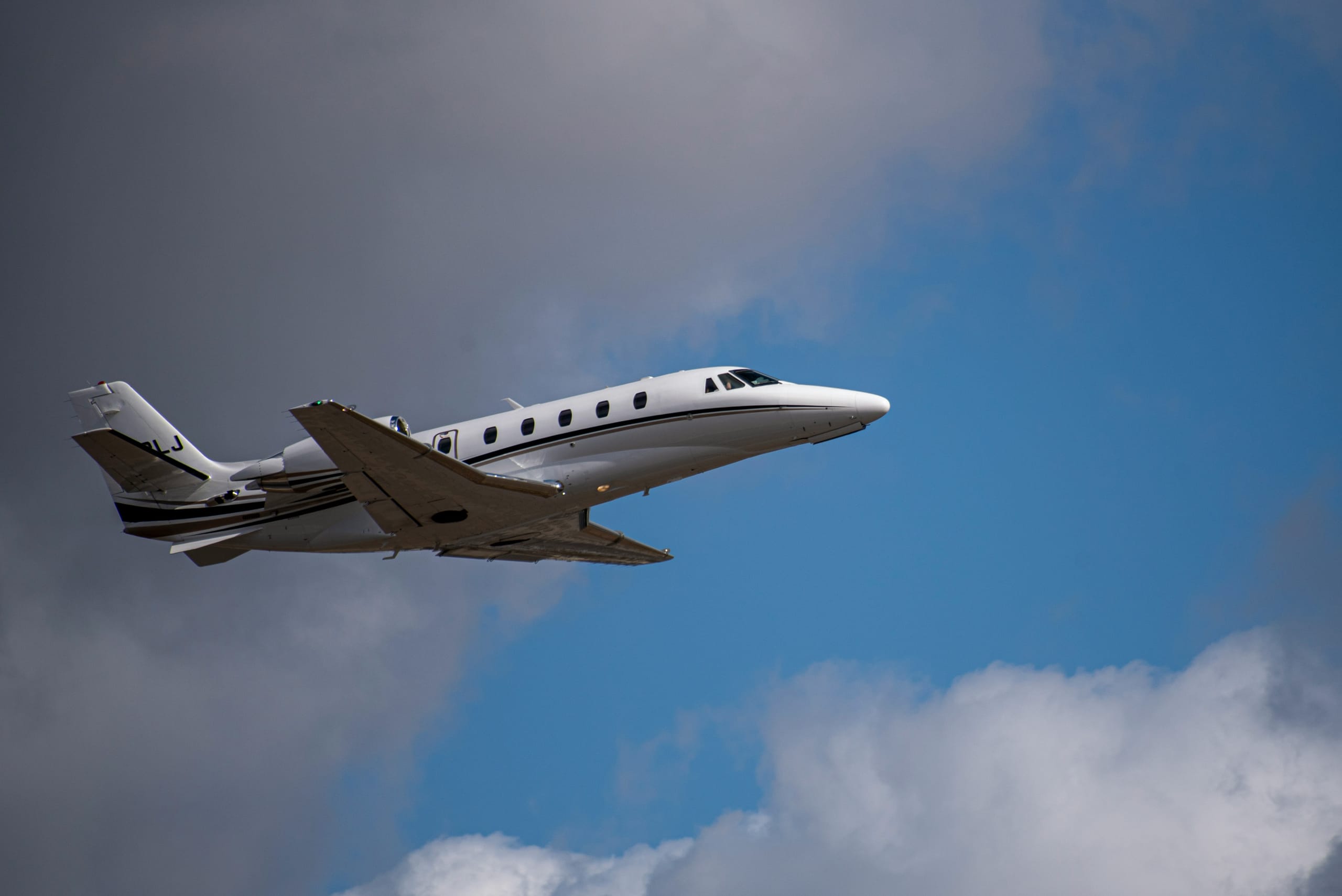 Business jet departing into a clear sky