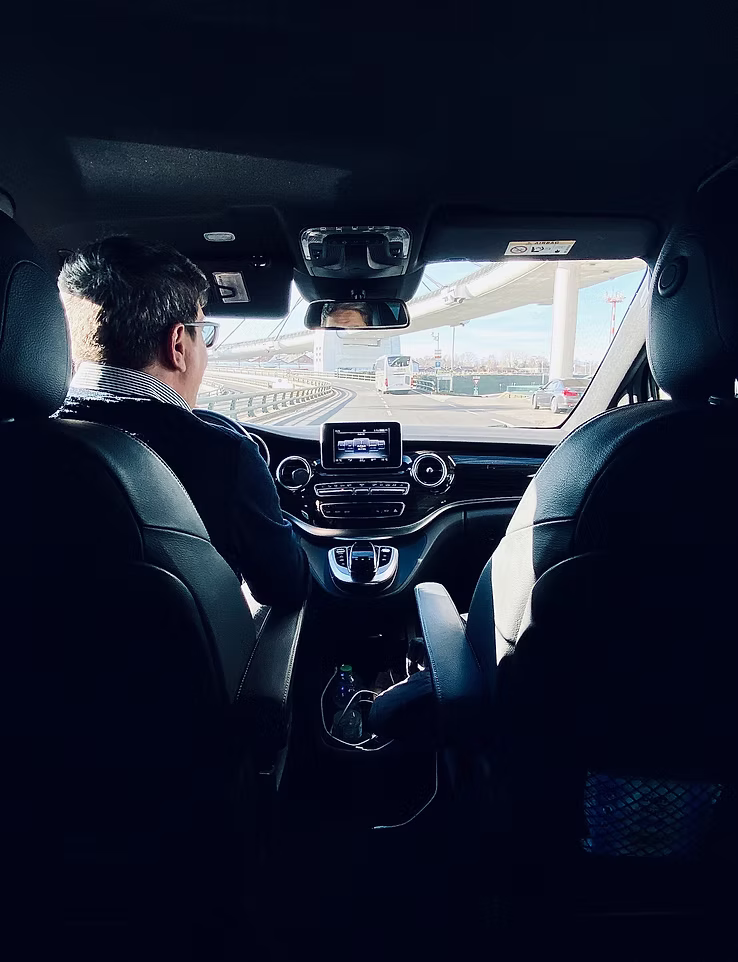A chauffeur at the wheel on the way into the region