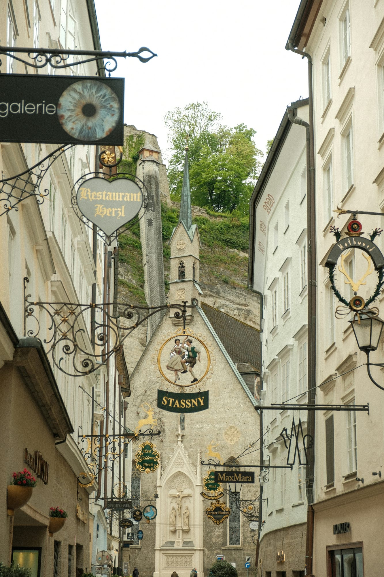 Ornate wrought-iron guild signs in a historic Salzburg old-town lane