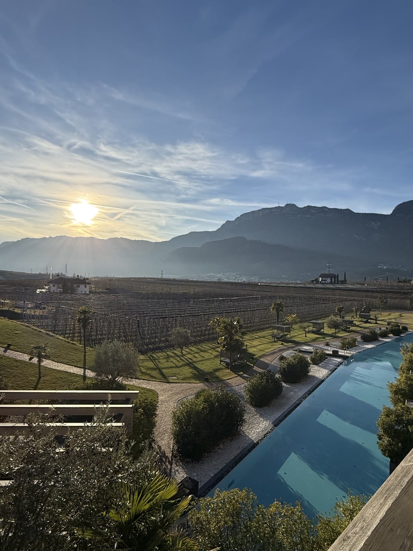 Vineyards and mountains in South Tyrol at golden hour, seen from a hotel terrace with a pool